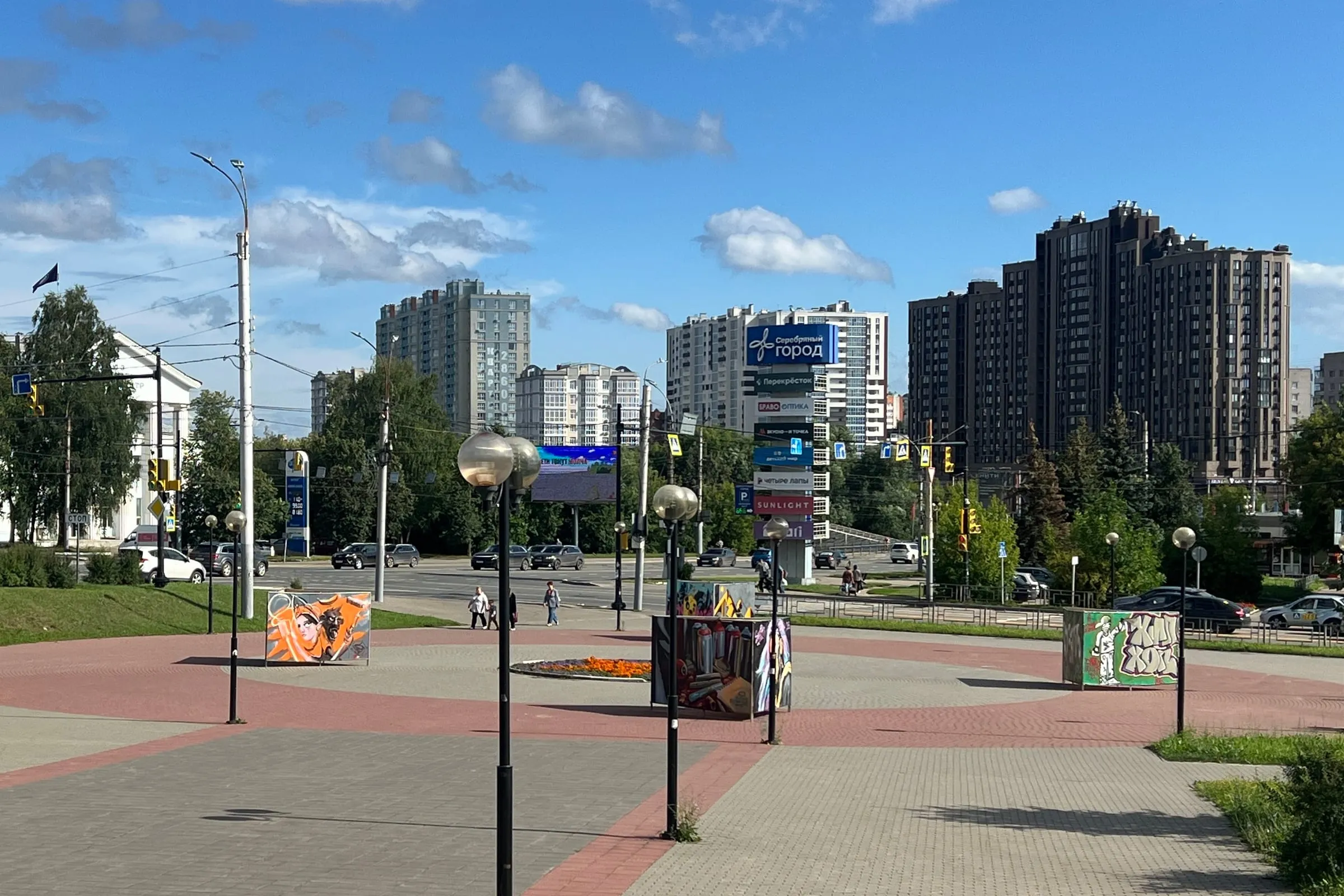 Широкая мощёная площадь в Иванове с рядами фонарей, за ней проезжая улица и городские высотки