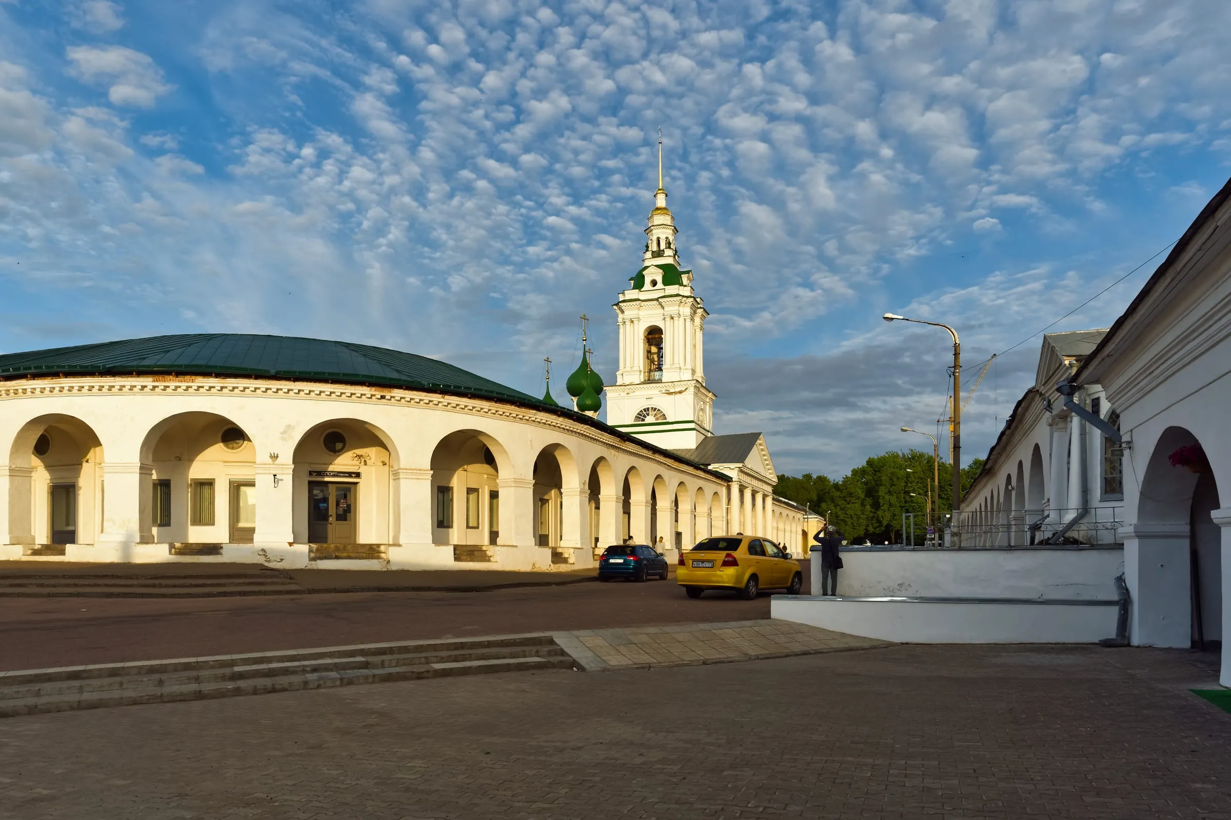 Костромские торговые ряды в вечернем свете, за ними колокольня Спасской церкви