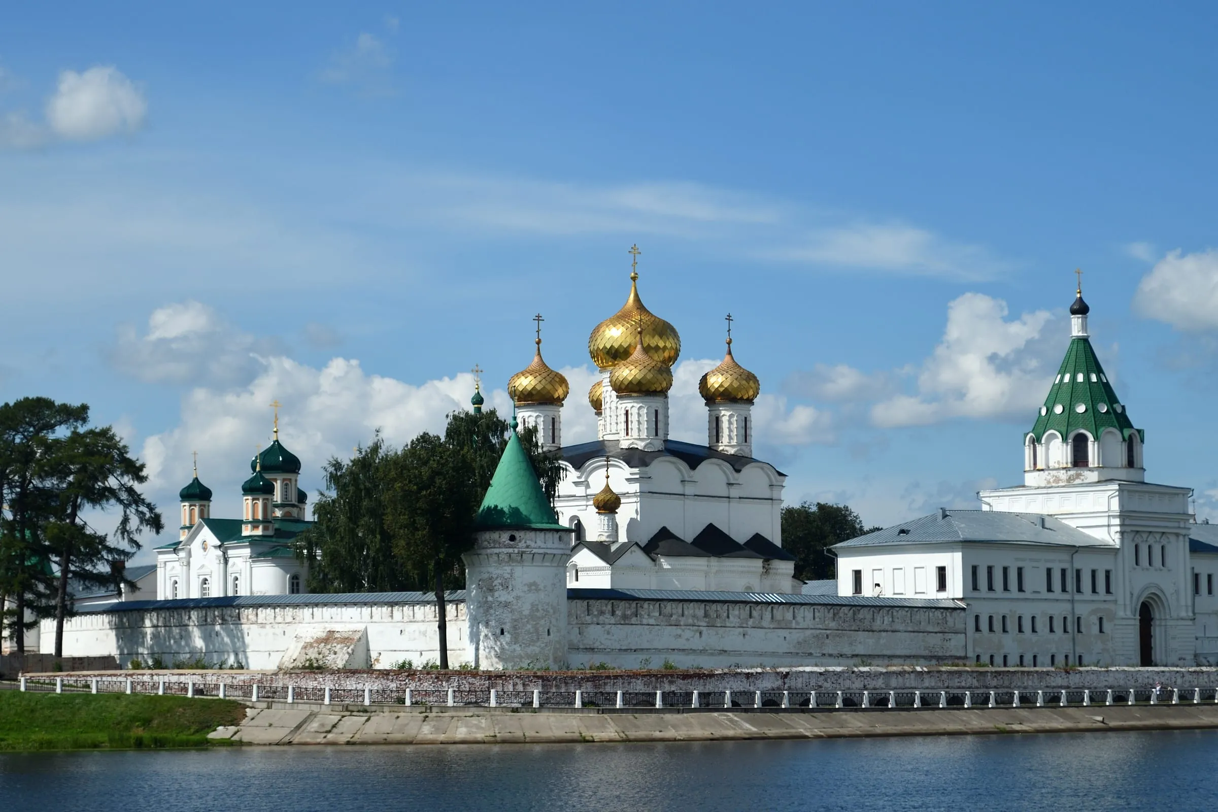 Ипатьевский монастырь в Костроме со стороны воды, белая стена и золотые купола Троицкого собора