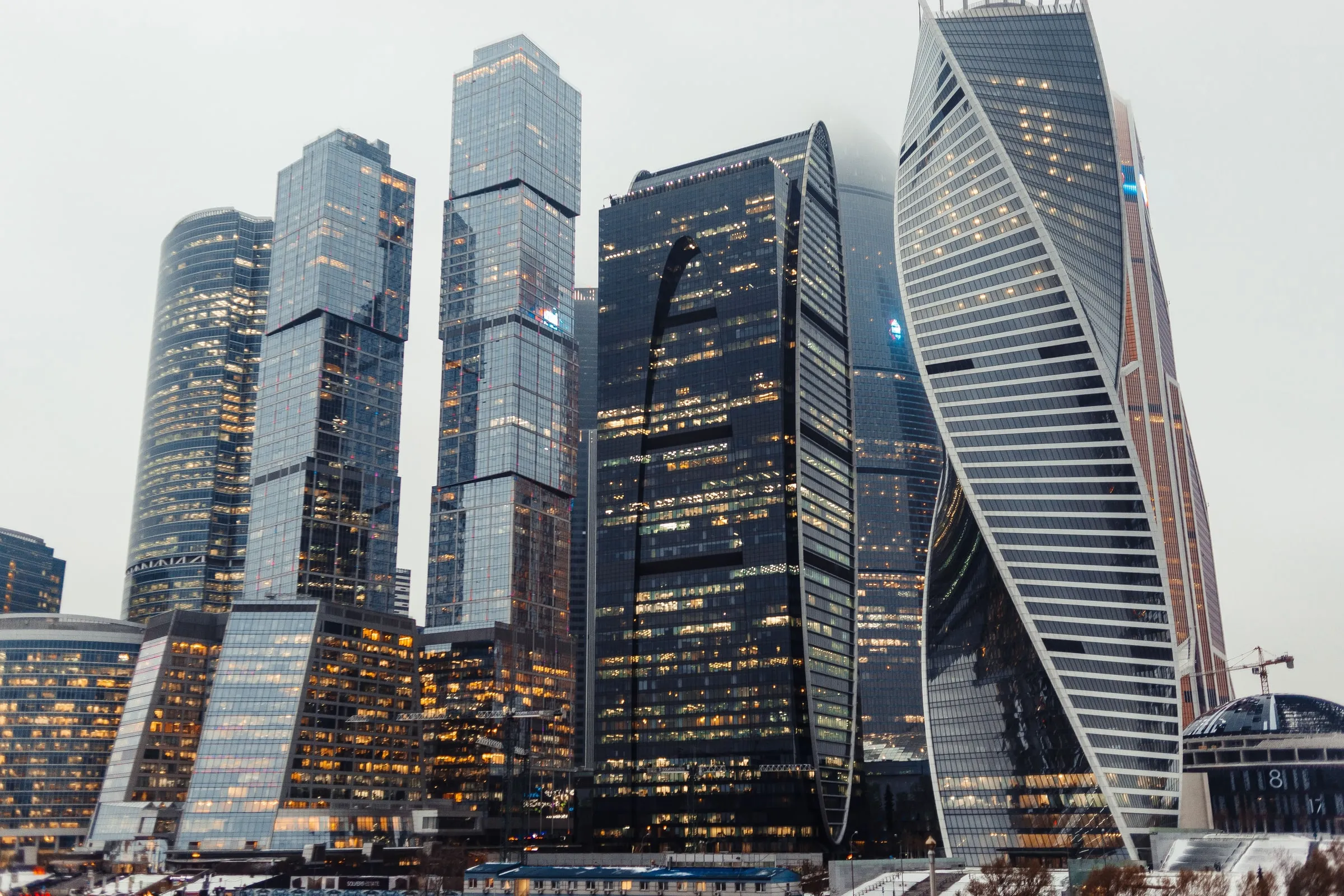 Небоскрёбы «Москва-Сити» в сумерках, в фасадах горят окна офисов