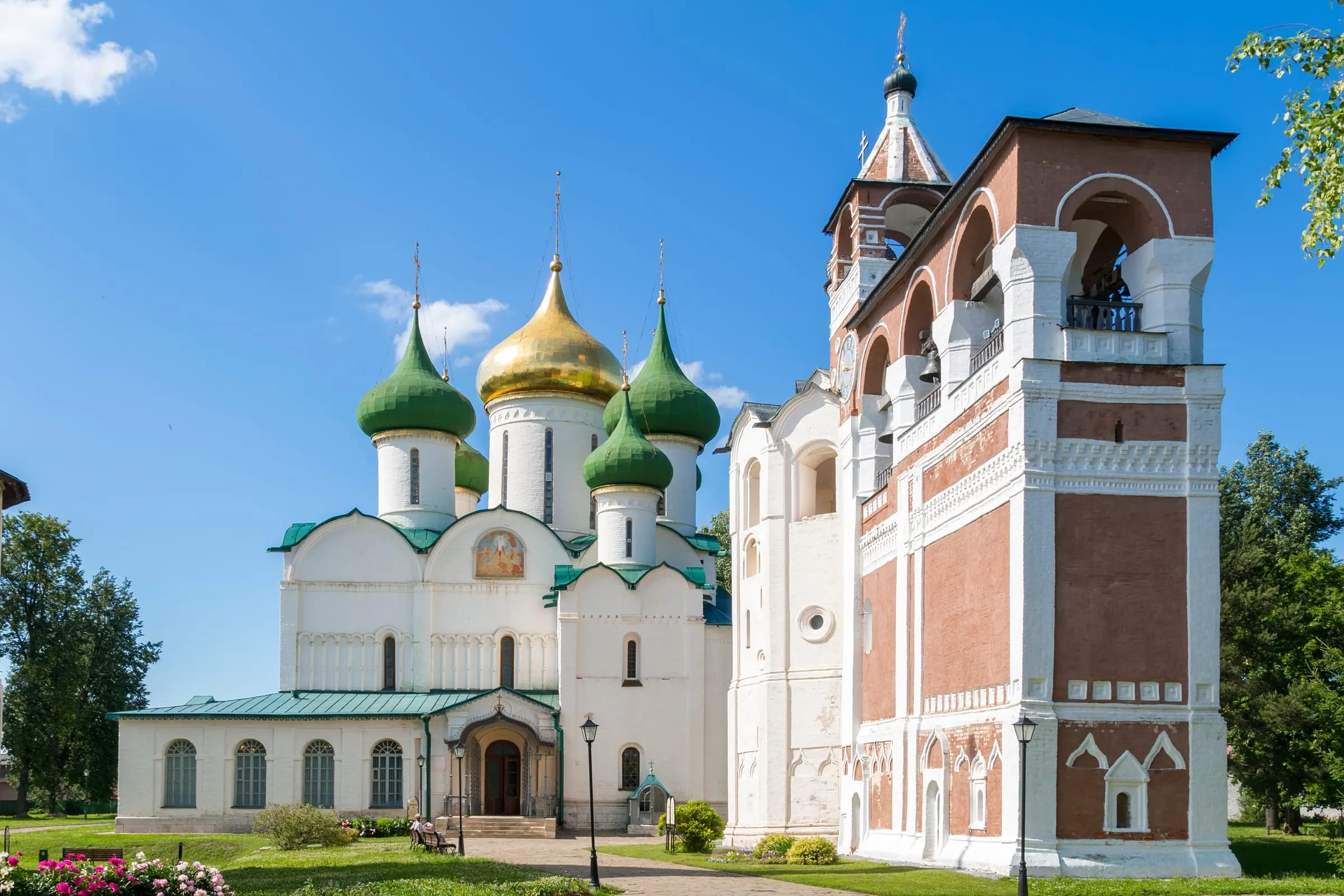 Спасо-Преображенский собор с золотым и зелёными куполами рядом с красной колокольней Спасо-Евфимиева монастыря в Суздале